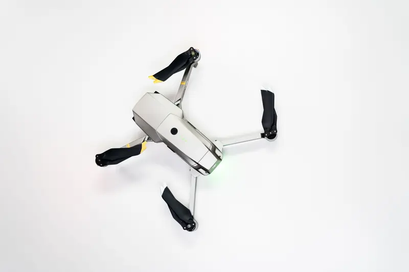Overhead shot of a quadcopter drone with folded propellers on a clean white background