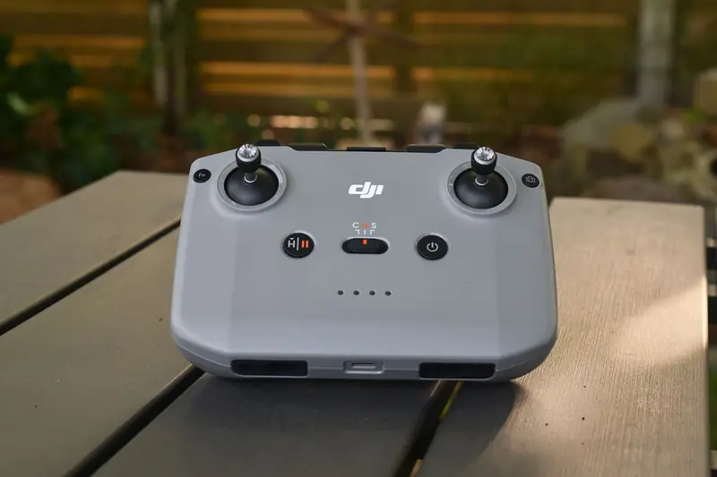 A sleek drone controller placed on a wooden table outdoors, ideal for remote flight enthusiasts