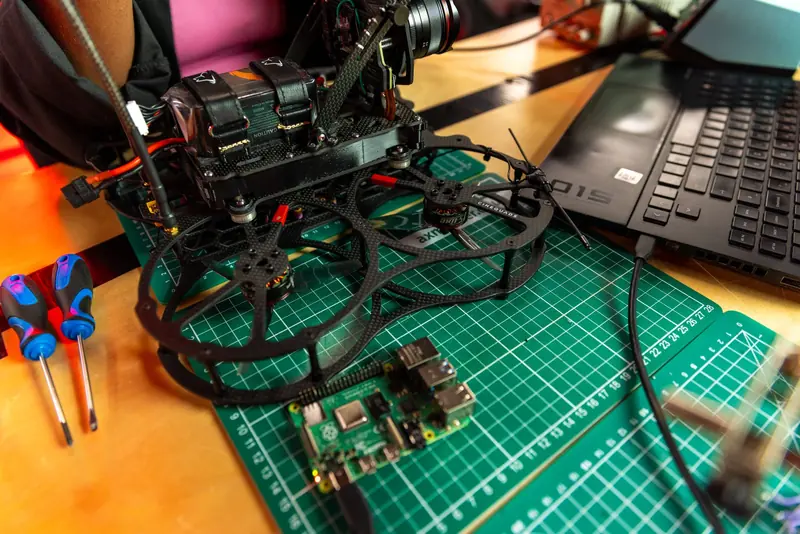 Drone assembly on a desk with laptop and tools, capturing modern tech