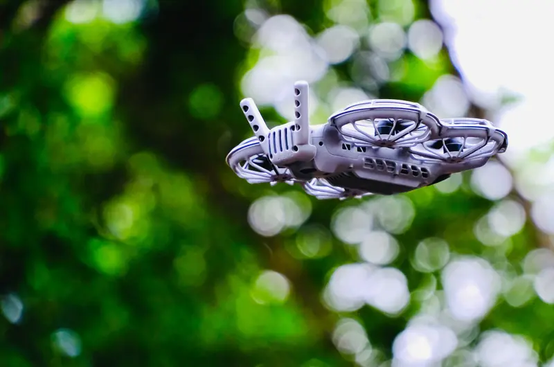 A close-up of a drone flying outdoors with a blurred green background, showcasing modern technology in Hong Kong