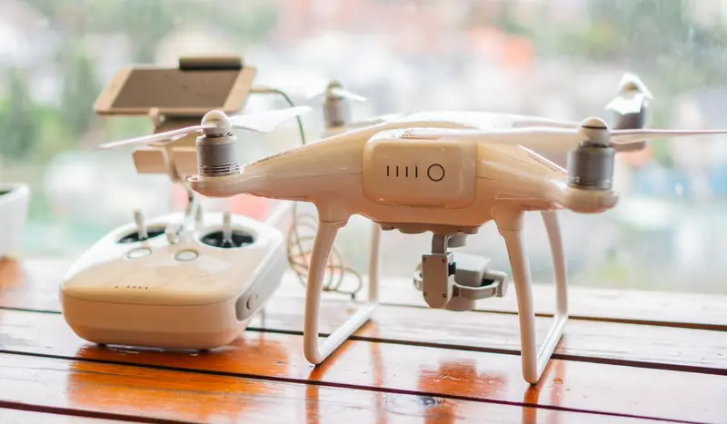 Close-up of a drone and controller on a table, indoor setting with a modern design
